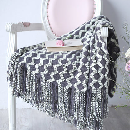 decorative knit blanket draped over couch in neutral living room